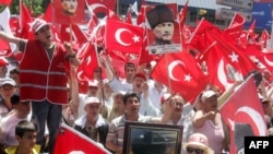Demonstrators wave the Turkish flag and portraits of Mustafa Kemal Ataturk.