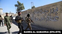 File - Members of Iraqi Shiite group known as Hashd al-Shaabi (The Popular Crowd) patrol an area in Tuz, southern Kirkuk city, Iraq, 17 October 2017