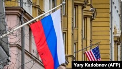 Российский флаг на фоне здания посольства США.
