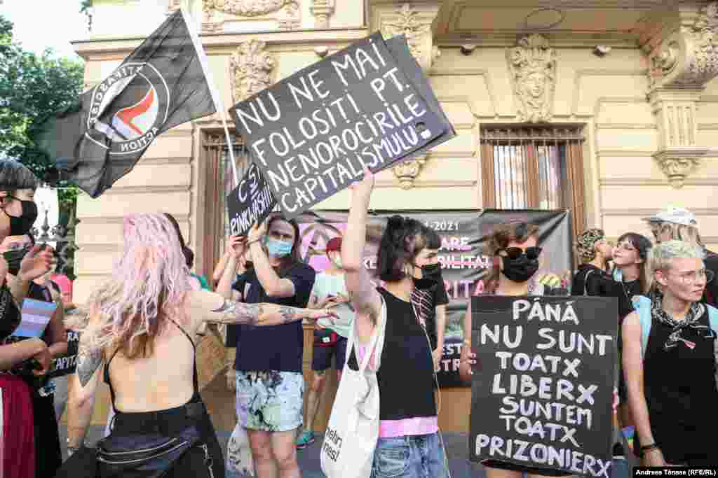 Tineri purtând pancarte participă la Bucharest Pride.