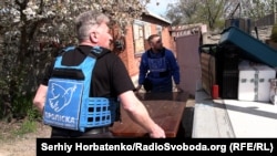 Співробітники гуманітарної місії «Проліска» завантажують меблі під час евакуації