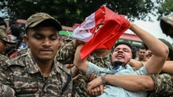 Security personnel detain a member of All India Youth Federation (AIYF) during a protest demanding the resignation of India's Chief Election Commissioner Gyanesh Kumar over alleged voter roll irregularities linked to the "special intensive revision" (SIR)