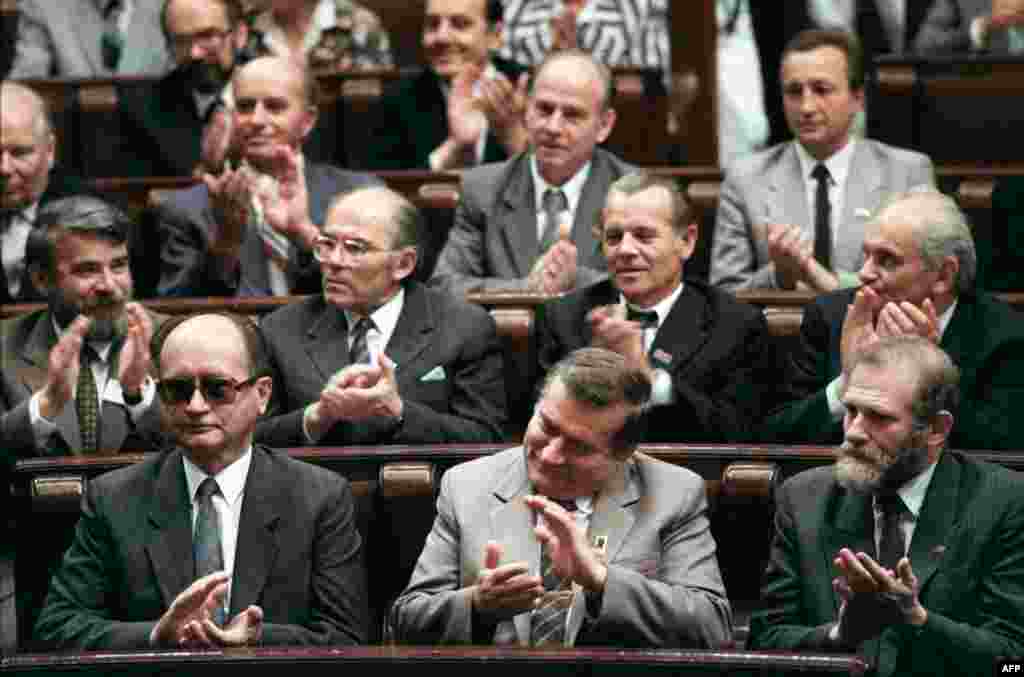 Jaruzelski, Solidarity leader Lech Walesa, and Solidarity adviser Bronislaw Geremek (front row, left-to-right) applaud during the first meeting in 50 years of Poland&#39;s parliament, the Diet, in Warsaw on July 4, 1989.