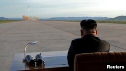 North Korean leader Kim Jong Un watches the launch of a Hwasong-12 missile in 2017.