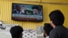 People look towards a television screen as US President Donald Trump, along with Iran's Supreme Leader Ayatollah Mojtaba Khamenei, is shown on a local channel as Pakistan prepares to host peace talks, in Islamabad, April 10