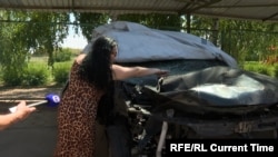 Наталя перевіряє вражену внаслідок російсього удару понівічену автівку у Краматорську