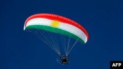 Paraglajder u bojama kurdske zastave iznad planinskog odmarališta Korek, blizu grada Ravanduz u severnom autonomnom kurdskom regionu Iraka, 16. februar 2026.