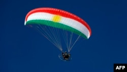 Paramotorist kürd bayrağının rəngləri ilə boyanmış paraşüt ilə İraqın şimalındakı muxtar kürd bölgəsinin üzərindən uçur.