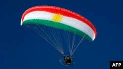 A paramotorist using a wing in the colors of the Kurdish flag flies over the Korek Mountain resort, near the city of Rawanduz in Iraq's northern autonomous Kurdish region, on February 16.