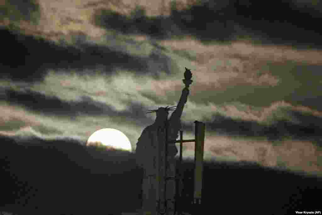 The moon rises over a replica of the Statue of Liberty in the Kosovar capital, Pristina. (AP/Visar Kryeziu)