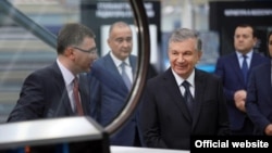 Президент Узбекистана Шавкат Мирзияев (второй справа) во время посещения предприятия по производству счетчиков, принадлежащего компании «Технопарк», которая выиграла тендер на установку миллионов приборов учета.