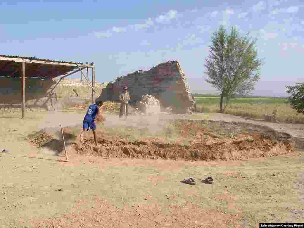 Kyrgyz children prepare the mud used to make clay bricks. 