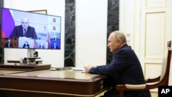 Pe candidatul Putin, încheierea înscrierii în cursa pentru „prezidențiale” l-a prins când se adresa prin video unei conferințe pe teme economice. În poza cea mai mare de pe ecran: premierul Mihail Mișustin. 