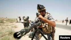 Members of the Iraqi security forces patrol an area near the borders between Karbala Province and Anbar Province on June 16.