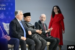 Presidentja e Kosovës, Vjosa Osmani, duke shkuar për ta zënë vendin e vet në mesin e liderëve botërorë në skenën e ceremonisë së nënshkrimit të Bordit të Paqes, në Davos.