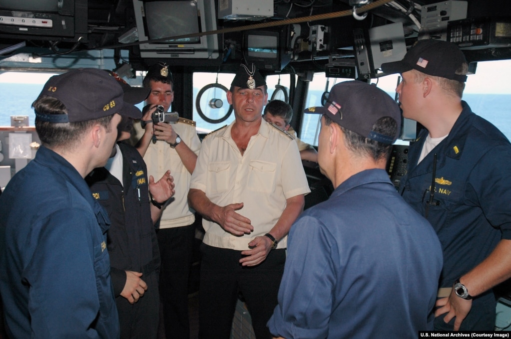 A Russian captain (center) speaks with U.S. Navy officers during his visit to the bridge of a U.S. guided missile cruiser.