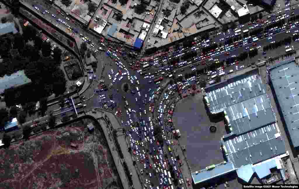 На тази сателитна снимка се виждат стотиците автомобили, които пристигат на летището в Кабул.