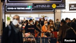 Utasok az izraeli Ben Gurion nemzetközi repülőtér járványtesztelési zónájában, Tel Avivban, 2021. november 28-án