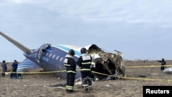 Emergency specialists work at the crash site of a passenger plane near Aqtau in Kazakhstan. 