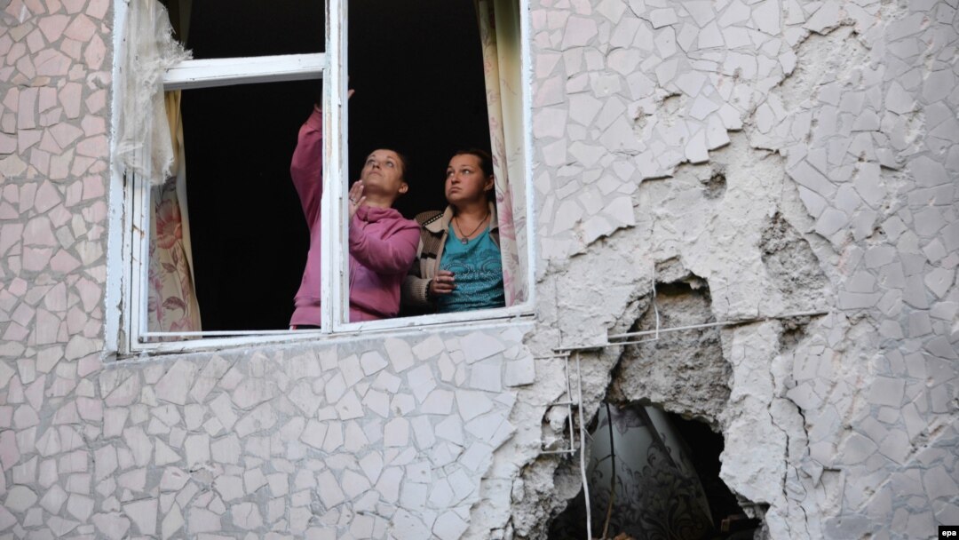 Locals fix a window shattered during shelling in Slovyansk.