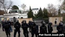 Policia çeke ruan zonën ndërsa protestuesit mblidhen përpara Ambasadës Ruse në Pragë. 