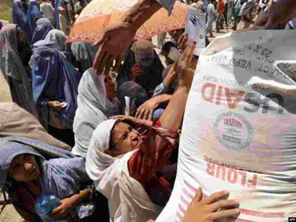 Food prices rise, pushing millions into hunger. - Afghan women try to get food donation from the World Food Program (WFP) in Kabul on July 21, 2008. Afghanistan's government and the United Nations launched a $404 million appeal on July 9 to help feed 4.5 million vulnerable Afghans. 