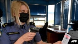 Një zyrtare policore në Slloveni verifikuar një certifikatë të vaksinës për koronavirus.