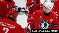 Vladimir Putin (right) fist bumps ice hockey player Aleksei Kasatonov during a friendly match on May 10.