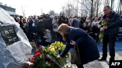 Relatives of Ukrainians who died in plane shot down by Iran attend ceremony unveiling memorial stone. February 17, 2020. 