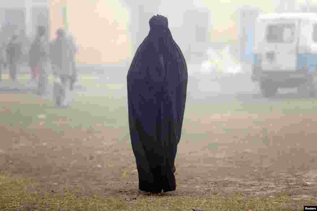 A woman wearing a burka leaves a polling booth after voting during state-assembly elections in Uttar Pradesh, India on February 15. (Reuters/Cathal McNaughton)