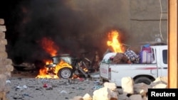 A car is engulfed by flames during clashes in Ramadi on May 16.