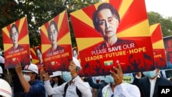 Участники протестов в Мьянме с изображением Су Чжи на плакатах