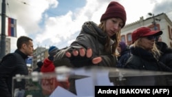 Građani ubacuju listiće u glasačku kutiju na štandu ispred Rektorata beogradskog Univerziteta kako bi podržali studente koji organizuju masovnu uličnu akciju prikupljanja potpisa građana kojima se zahtevaju vanredni parlamentarni izbori, 28. decembra 2025.