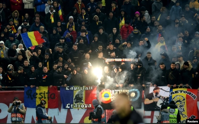 Tifozët rumunë mbajnë flamuj dhe ndezin flakadanë gjatë ndeshjes mes Rumanisë dhe Kosovës në Ligën e Kombeve, e cila u braktis nga kosovarët që i akuzuan rumunët për thirrje raciste dhe anti-Kosovë.
