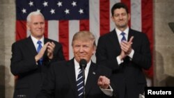 U.S. -- Vice President Mike Pence (L) and Speaker of the House Paul Ryan (R) applaud as US President Donald J. Trump (C) arrives to deliver his first address to a joint session of Congress from the floor of the House of Representatives in Washington, Fe