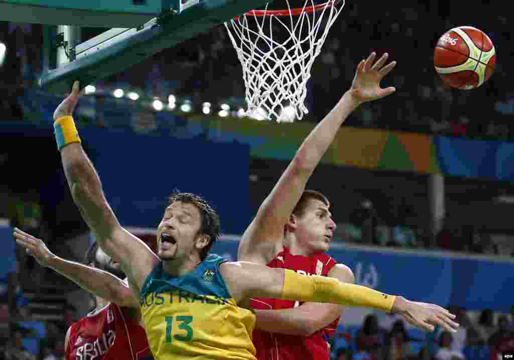 David Andersen of Australia (center) is crowded out by the Serbian defense during their men&#39;s basketball semifinal. The Serbs eventually triumphed 87-61.