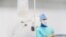 Belarus - Closeup saline intravenous drip. Surgeon is in the operating room on a background. Undated