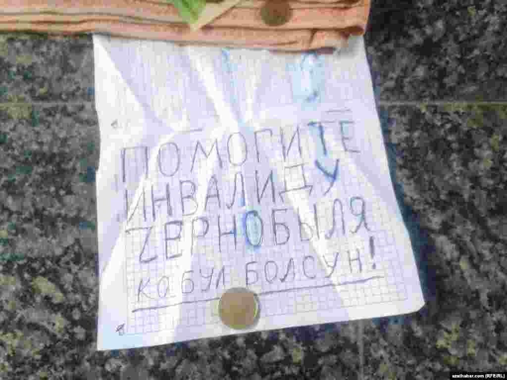 Inwalid üçin kömek soraýan ýaşulynyň öňünde goýan kagyzy