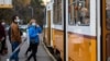 A koronavírus járvány miatt védőmaszkot viselő utasok a budapesti villamosmegállóban 2020. október 31-én.