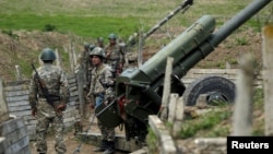 Nagorno-Karabakh -- Ethnic Armenian soldiers stand next to a cannon at artillery positions near the Nagorno-Karabakh's town of Martuni, April 7, 2016