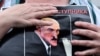 Un protestat ține un portret al președintelui Lukașenko cu mesajul „Opriți criminalul" în timp ce strânge semnături pentru opoziție