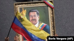 Nicolas Maduro tərəfdarları Karakasda onun portretini qaldırır, 1 may, 2019-cu il