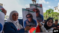 Palestinieni și activiști internaționali țin portrete ale activistei turco-americane Aysenur Ezgi Eygi la ceremonia funerară, după ce aceasta a fost ucisă de forțele israeliene în timpul unor proteste din Cisiordania. 8 septembrie 2024.