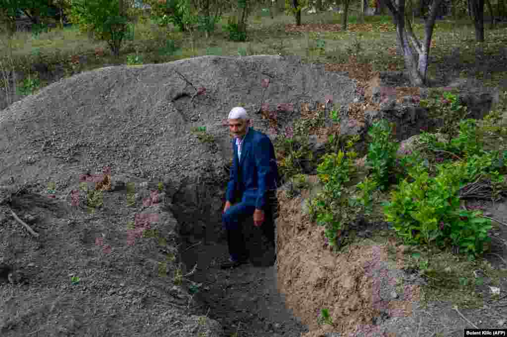 Микаил Исмаилов выходит из траншеи возле своего дома, выкопаной для защиты от снарядов и ракет, 14 октября