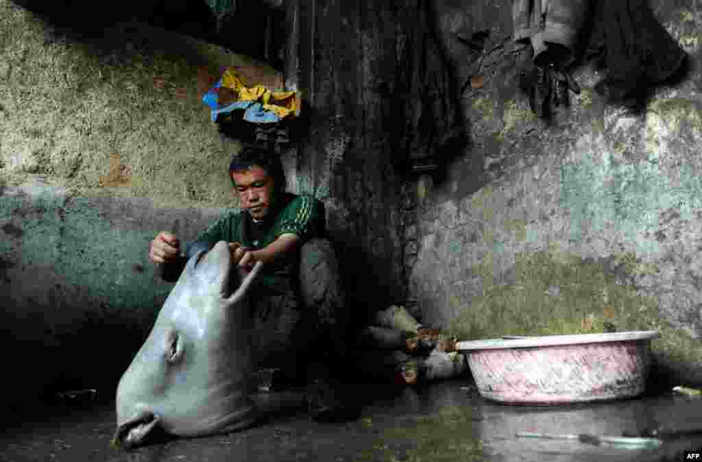 An Afghan day laborer skins a cow&#39;s head in Mazar-e Sharif. (AFP/Farshad Usyan)