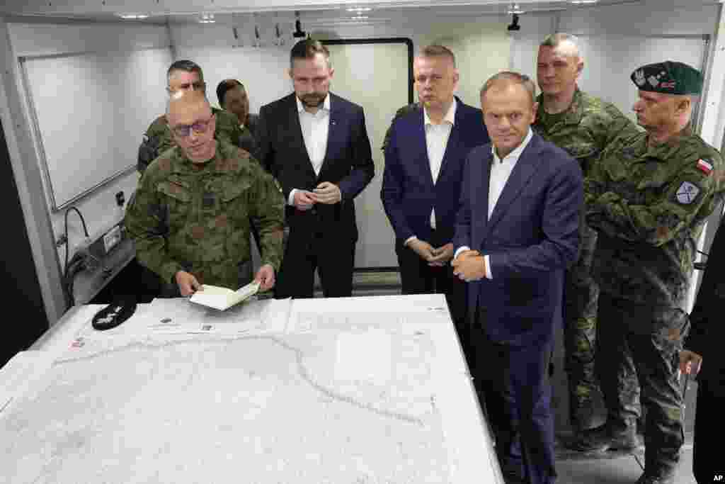 Poland&#39;s Prime Minister Donald Tusk (front right), Defense Minister Wladyslaw Kosiniak-Kamysz (center) and Interior Minister Tomasz Siemoniak (center right) visit troops in Dubicze Cerkiewna, eastern Poland, on May 29. &ldquo;We are not dealing with (just) any asylum seekers here, we are dealing with a coordinated, very efficient -- on many levels -- operation to break the Polish border and attempts to destabilize the country,&rdquo; Tusk said.