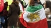 A demonstrator wearing a pre-1979 Iranian flag with the Lion and Sun emblem attends a rally in support of the Iranian people following the killing of Iran's Supreme Leader Ali Khamenei in a joint US-Israeli strike, in Brussels on March 1.