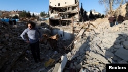 Човек стои среде урнатините оставени од зграда уништена од напад, Техеран, 22 март 2026