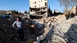 A man stands in the middle of the rubble left of a building that was destroyed by a strike in Tehran on March 21.