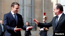 French President Emmanuel Macron (left) escorts former President Francois Hollande after the handover ceremony at the Elysee Palace in Paris on May 14.